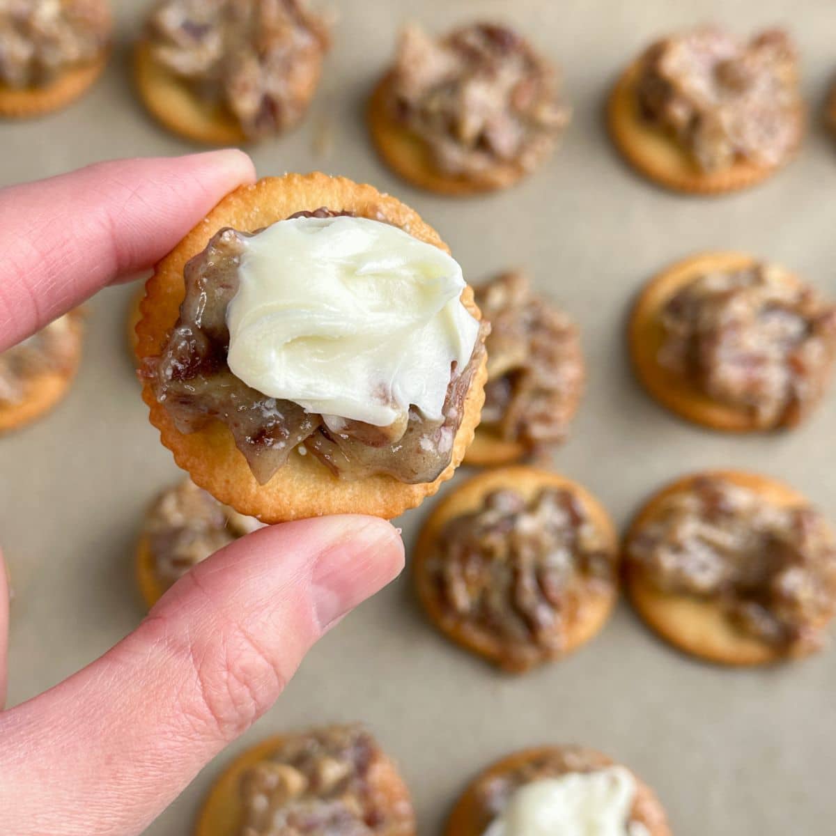 Ritz cracker topped with pecans and cream cheese frosting. 