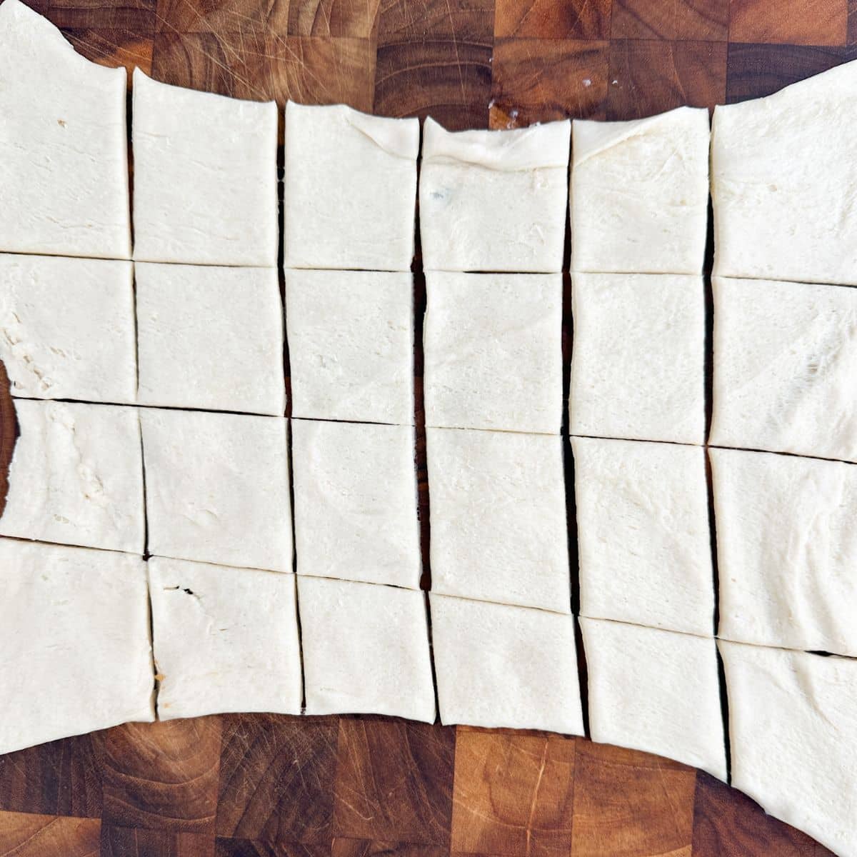 Crescent roll dough rolled out and cut into squares. 