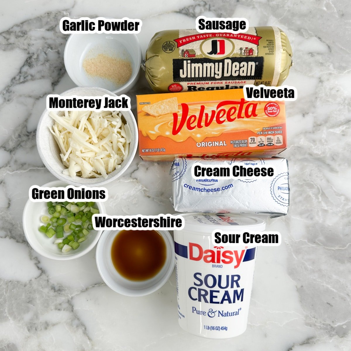 Cream cheese, Velveeta cheese, shredded cheese, sausage, sour cream, green onions, garlic powder, and Worcestershire.