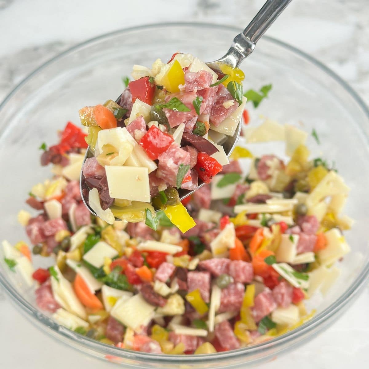 Bowl of muffuletta dip with a spoon.