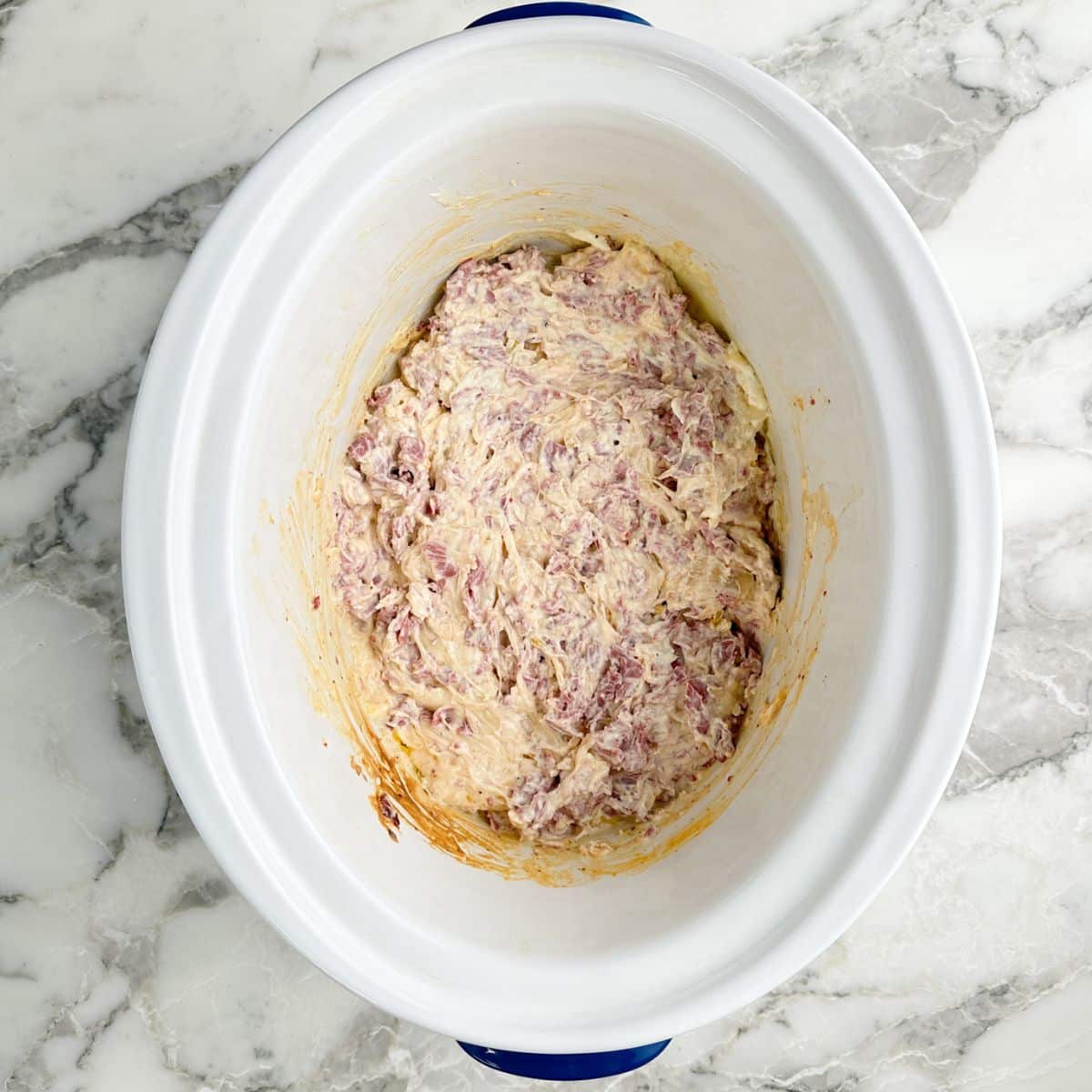 Cheesy reuben dip in a slow cooker.