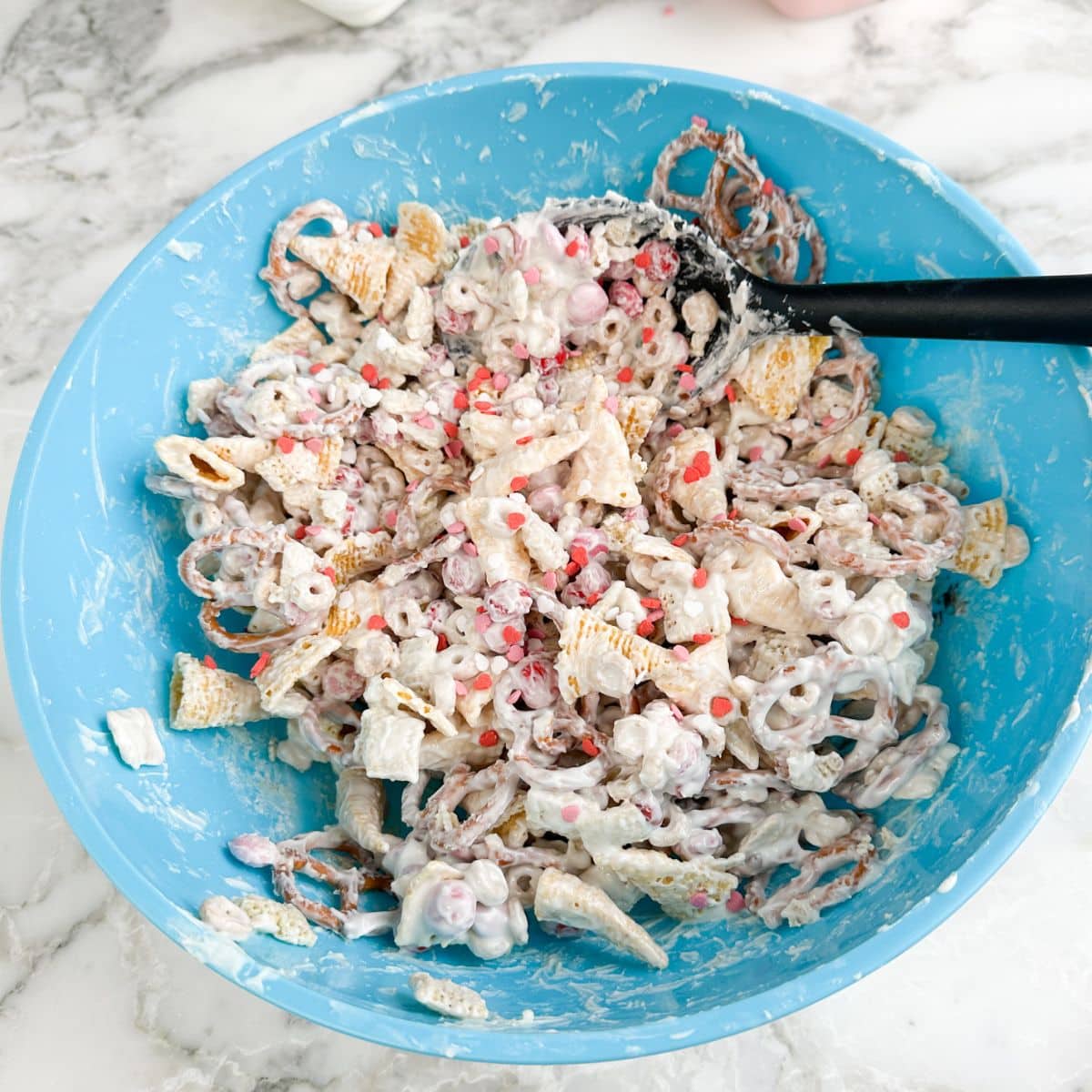 Blue bowl with Valentine's day snack mix.