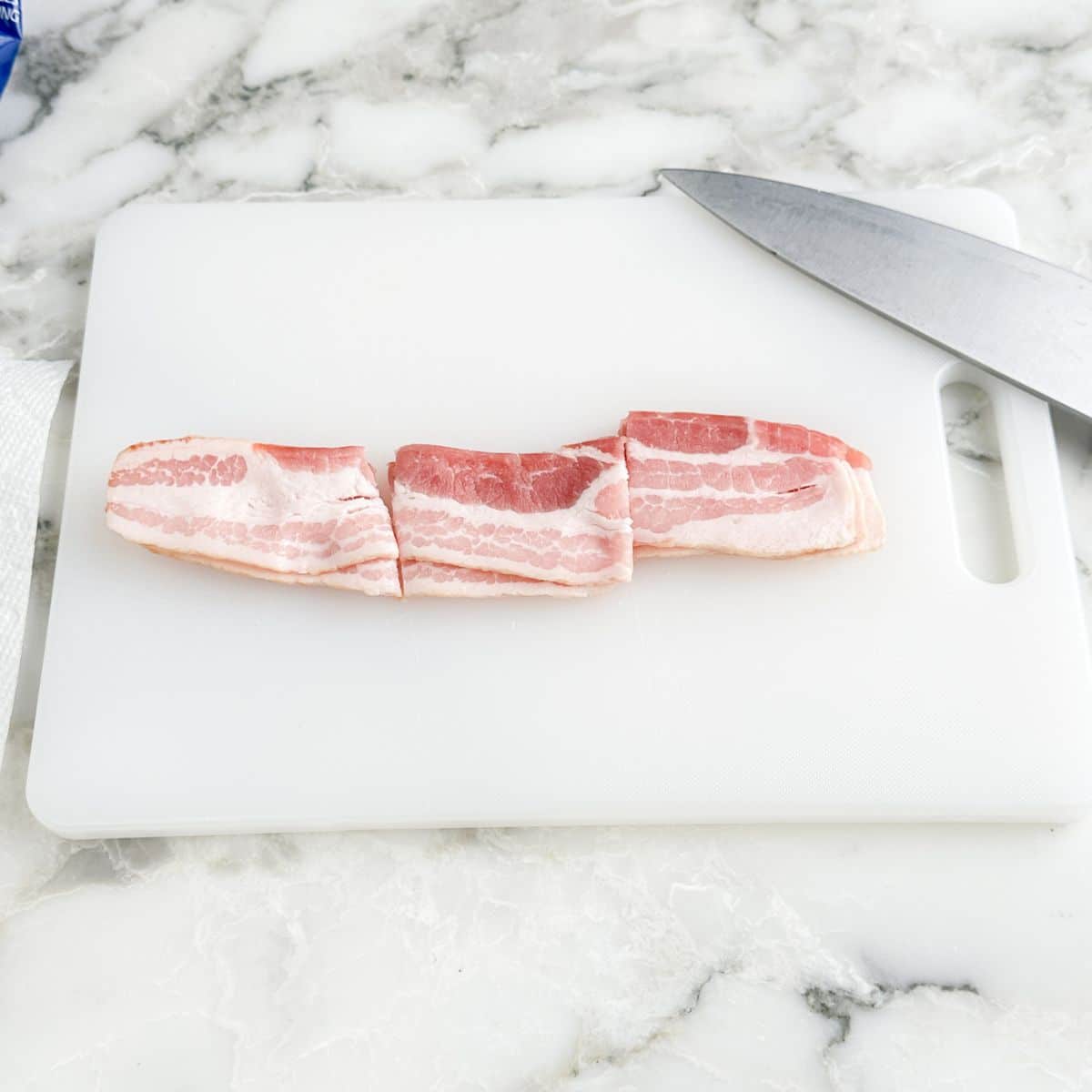 Uncooked bacon cut into three sections. 