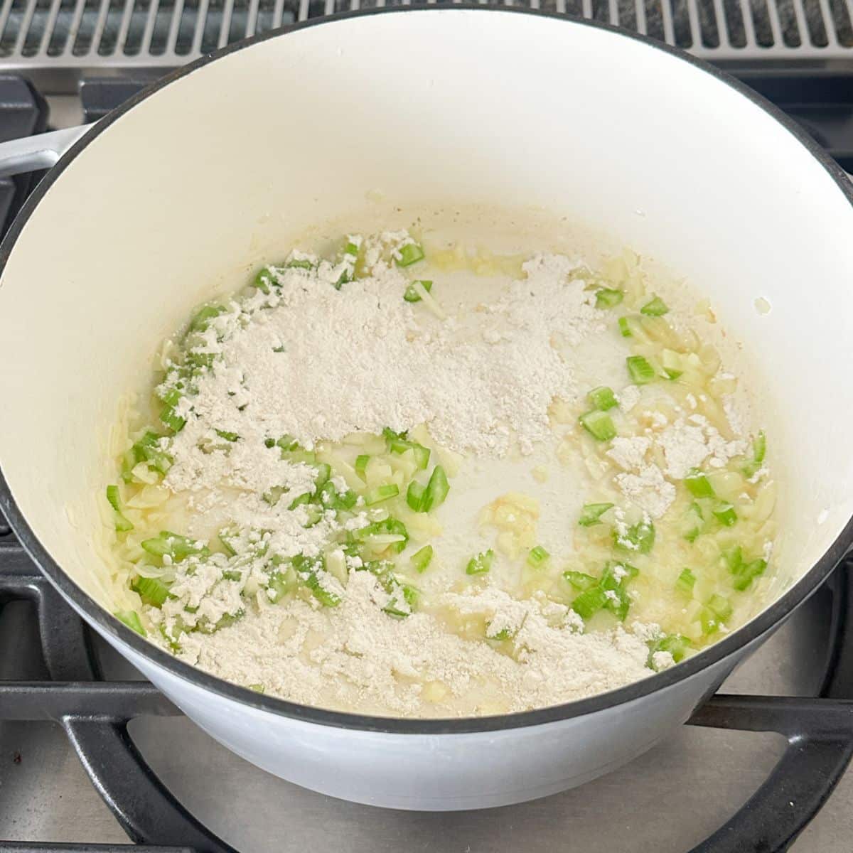 Pot with melted butter, diced onion, celery, and flour.