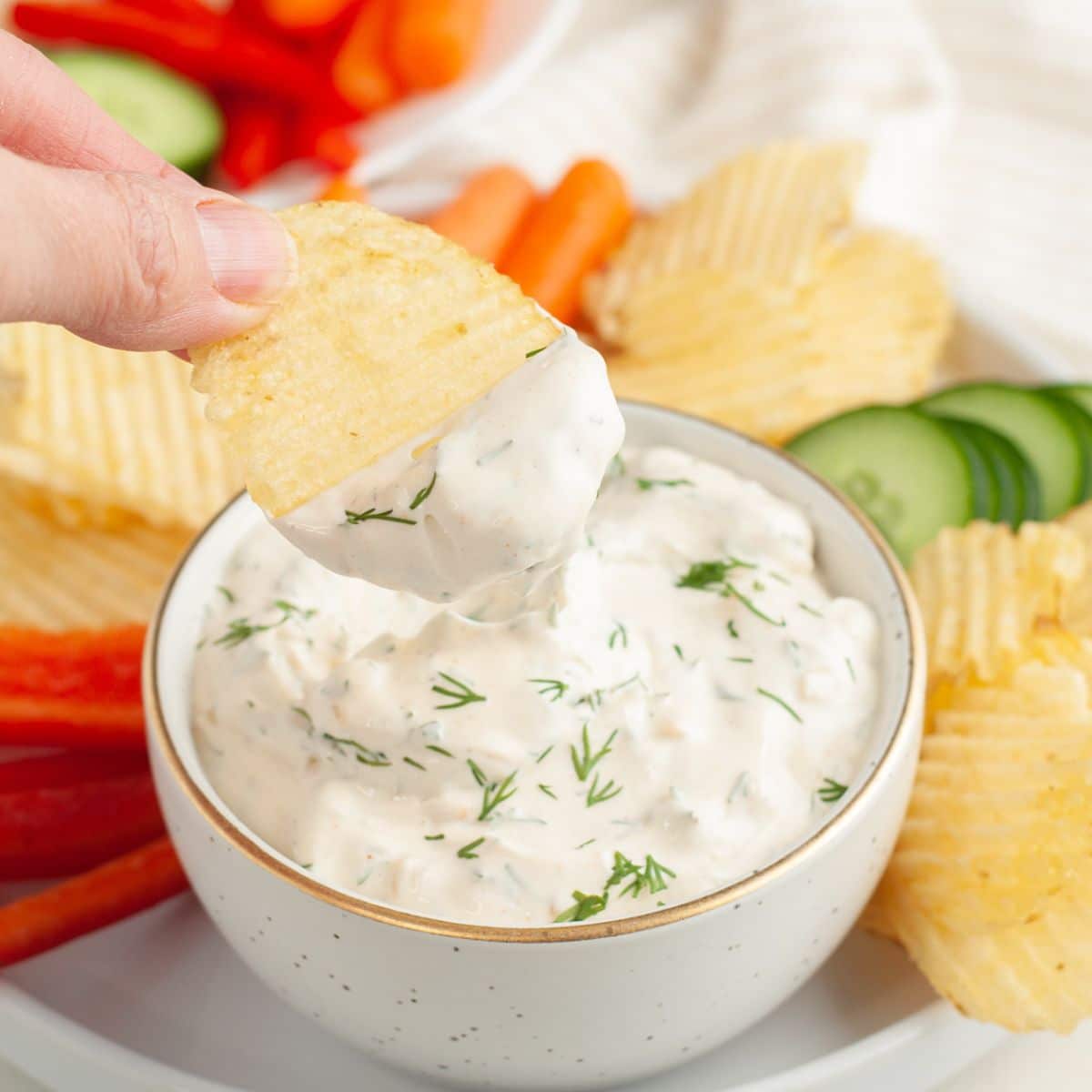 Bowl of dill dip with a chip. 