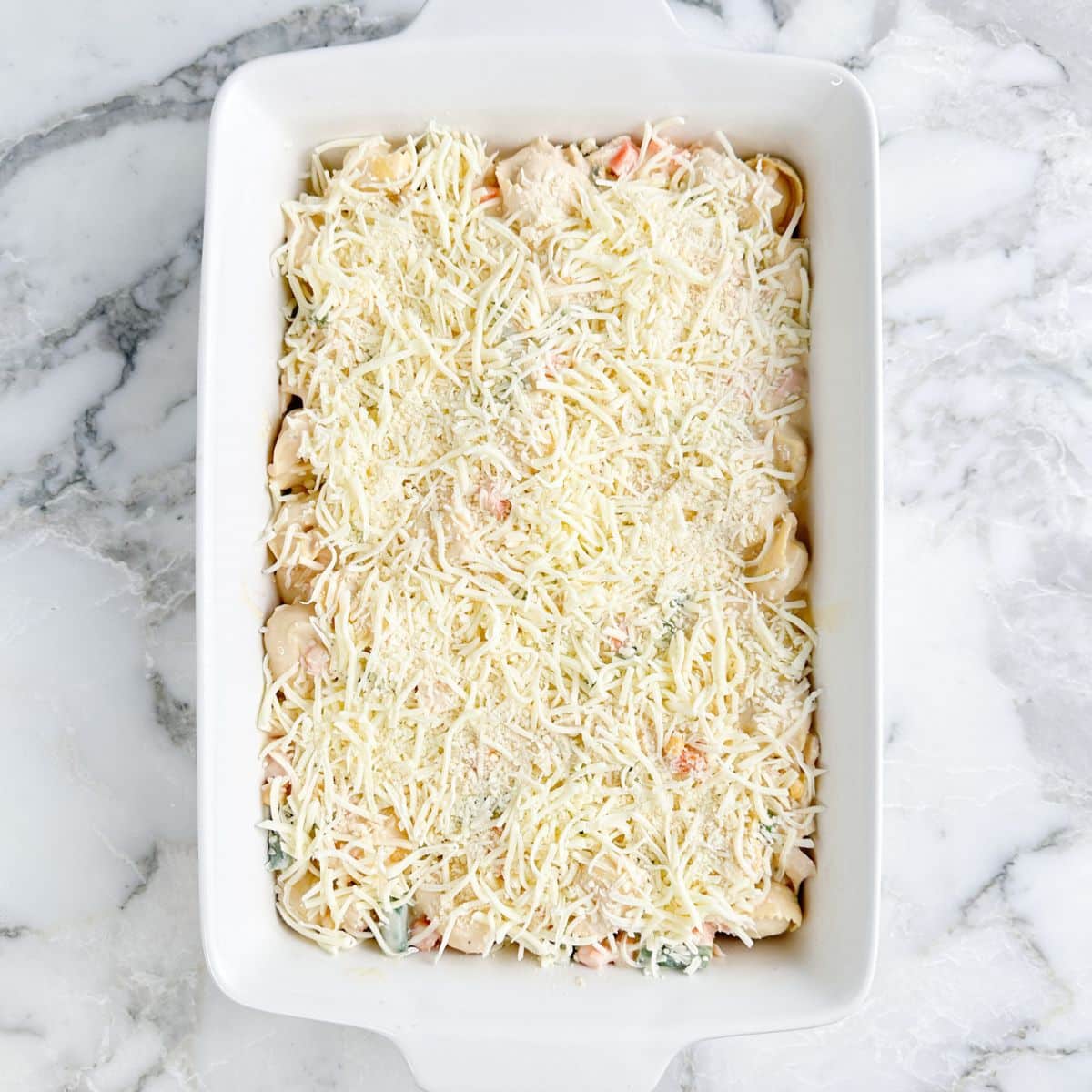 Casserole dish with unbaked chicken tortellini casserole. 