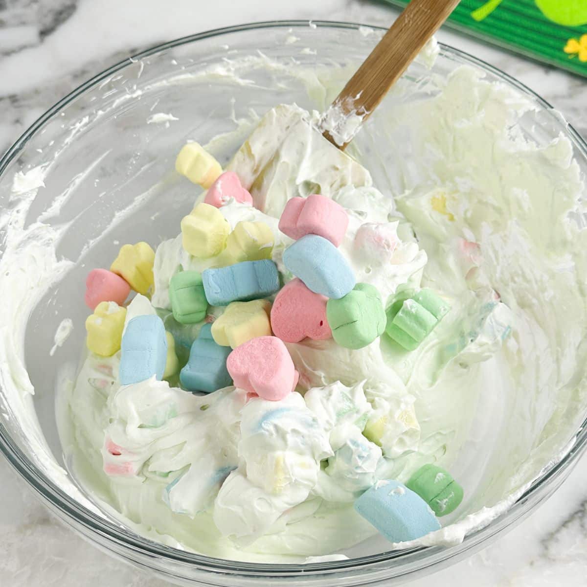 Bowl of green dip with colorful marshmallows. 
