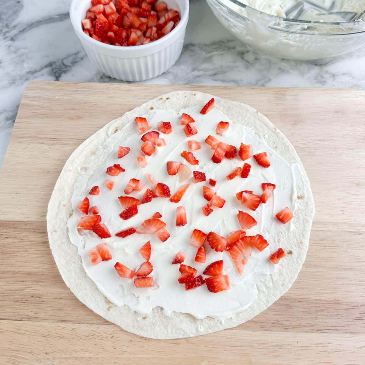Tortilla with cream cheese and diced strawberries on top. 