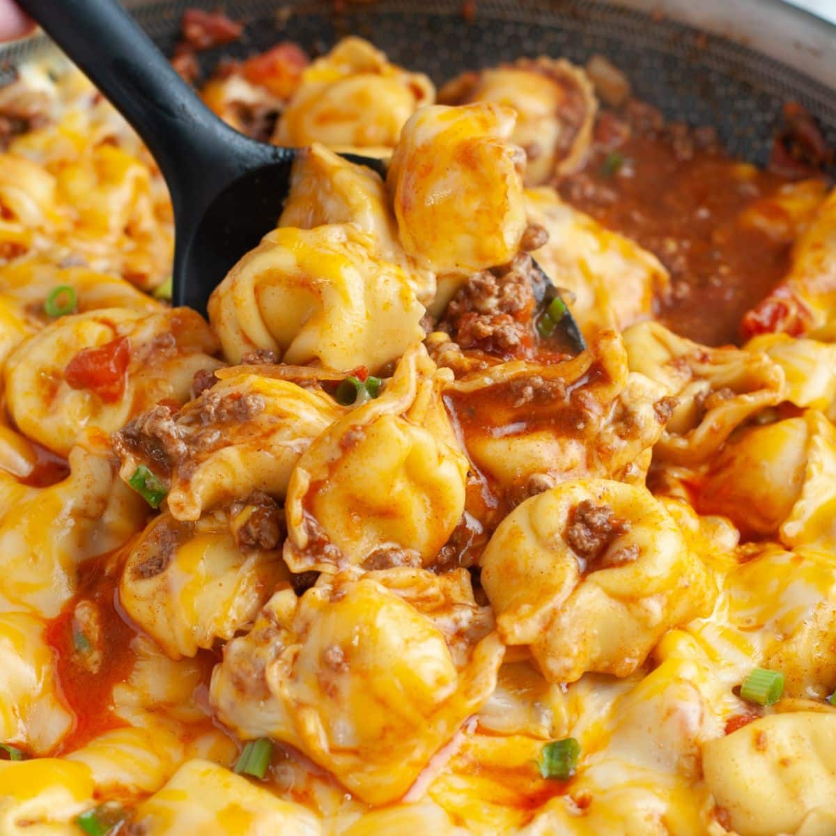 Spoon with cheesy taco tortellini.