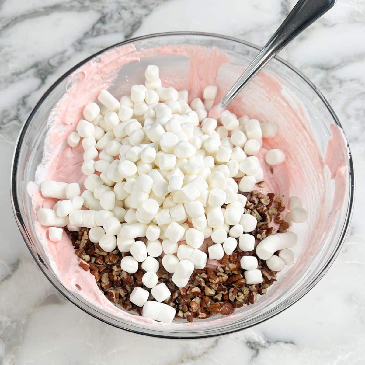 bowl with strawberry fluff with mini marshmallows and chopped pecans. 