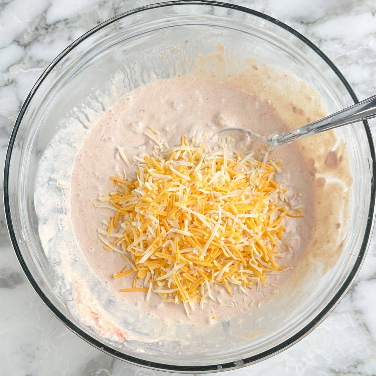 Bowl of fiesta dip with shredded cheese. 