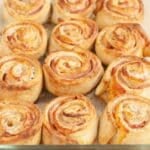 Ham and cheese pinwheels in a baking dish.