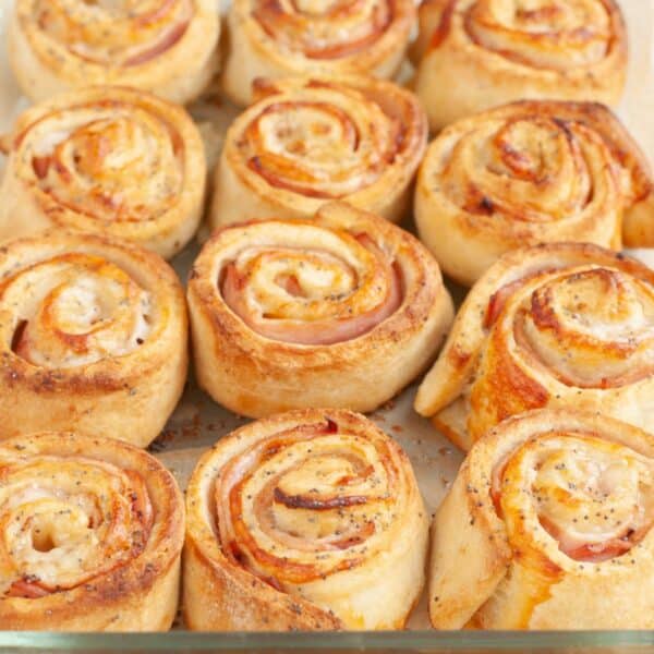 Ham and cheese pinwheels in a baking dish.