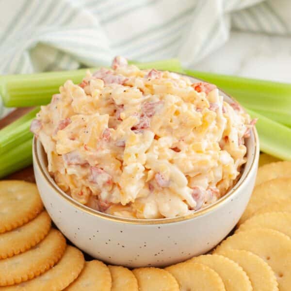 Bowl of pimento cheese surrounded by crackers.