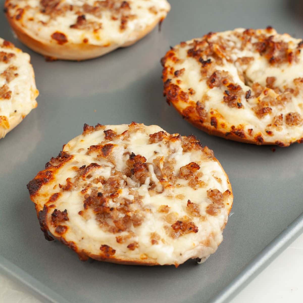 School breakfast pizza bagel with sausage and cheese. 