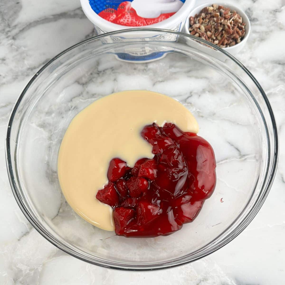 Bowl with sweetened condensed milk and strawberry pie filling.