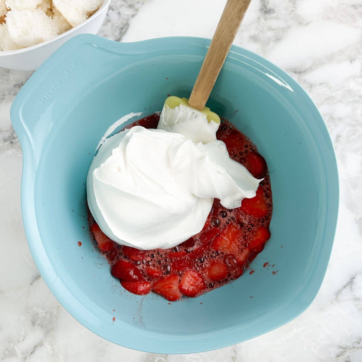 Bowl with frozen strawberries and whipped cream. 