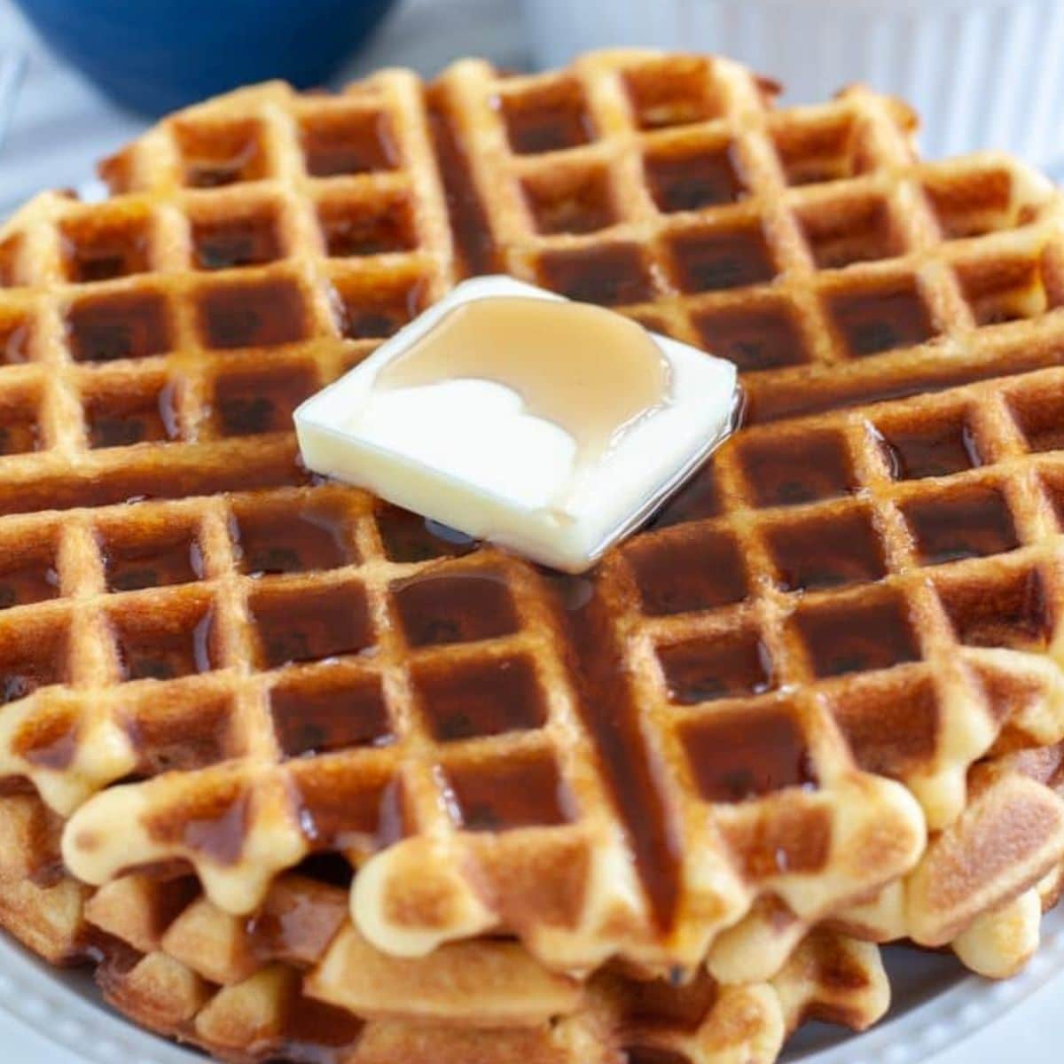 Stack of cake mix waffles with a pat of butter.