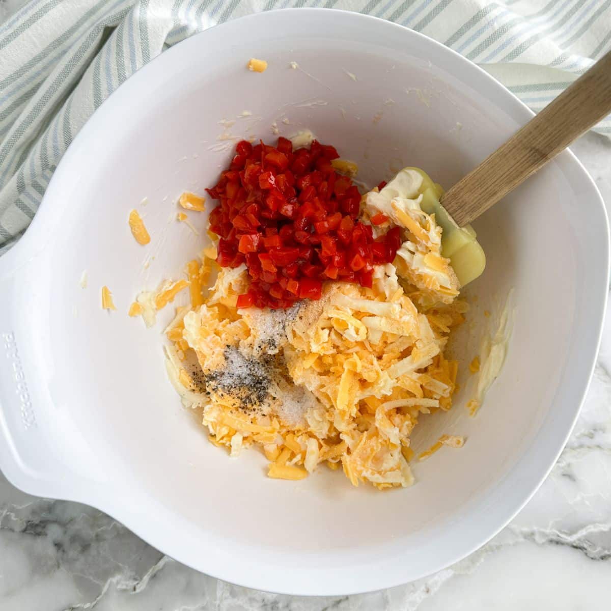 Bowl of shredded cheese, pimentos, and seasoning. 