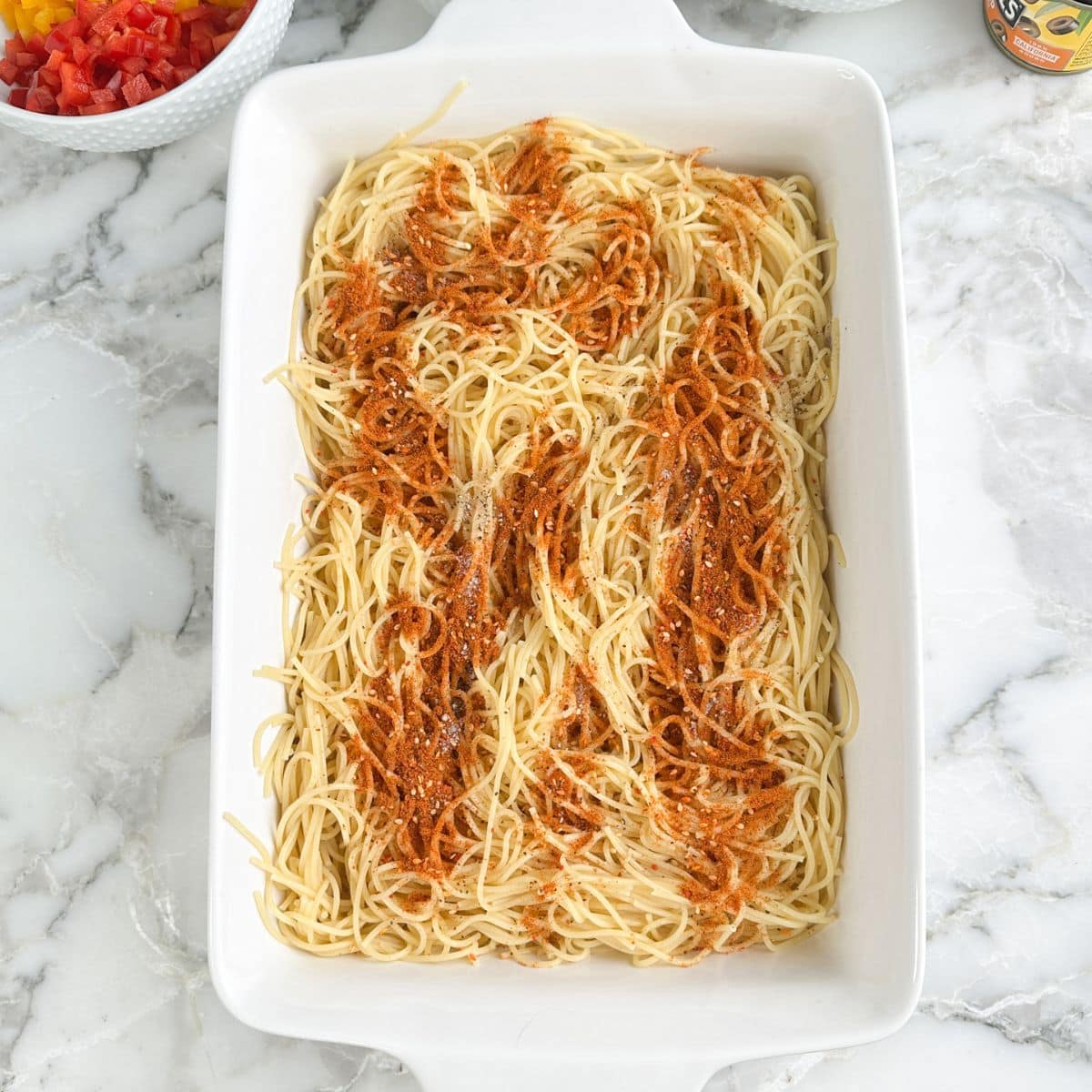 Casserole dish with spaghetti noodles and Salad Supreme seasoning. 
