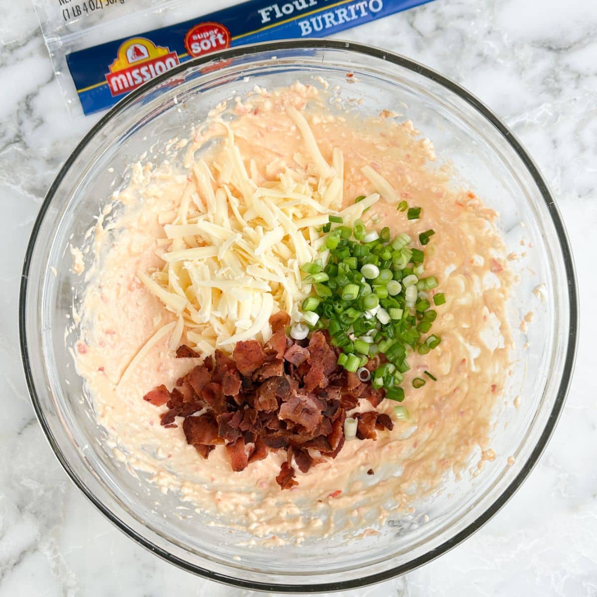 Bowl of pepper jelly, cheese, bacon, and green onions.
