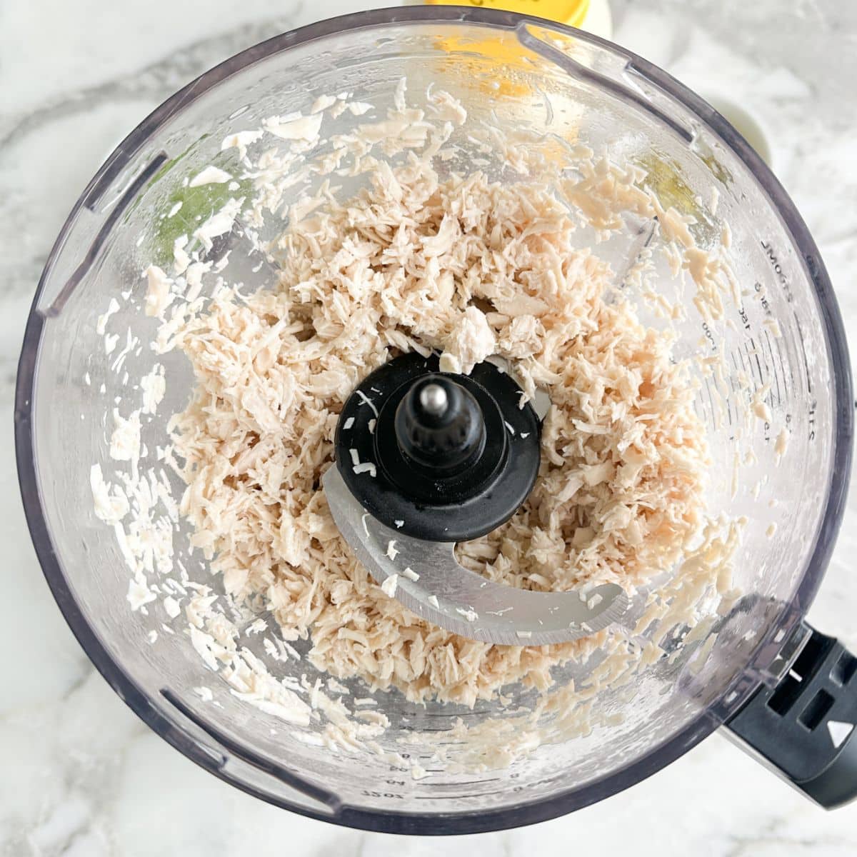 Shredded chicken in a food processor. 