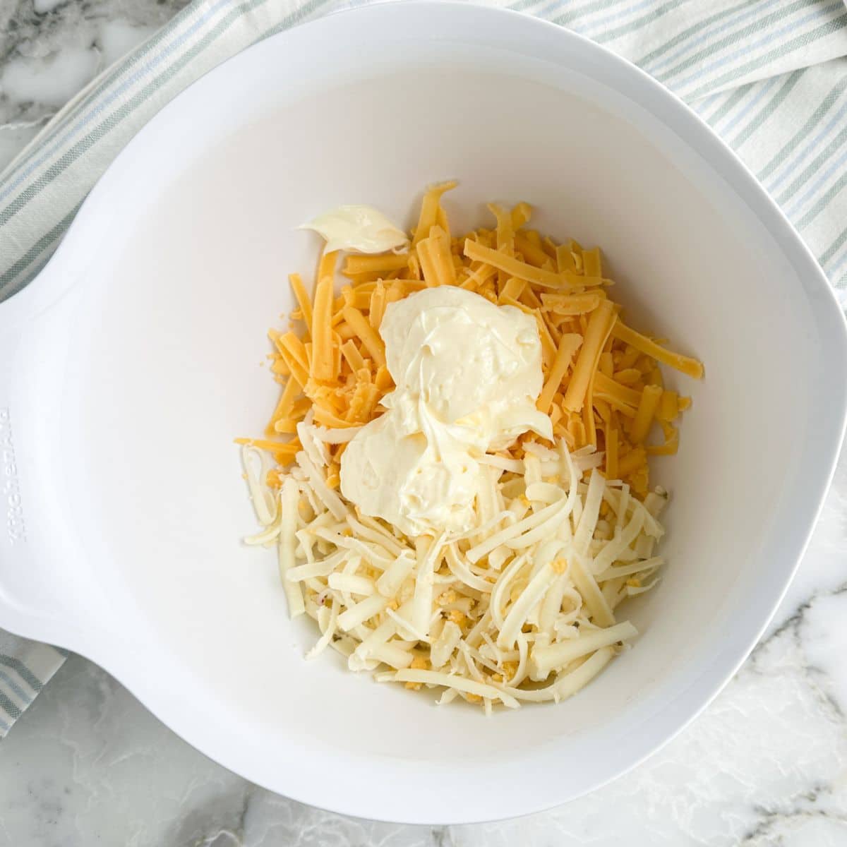 Bowl of shredded cheese and mayonnaise. 