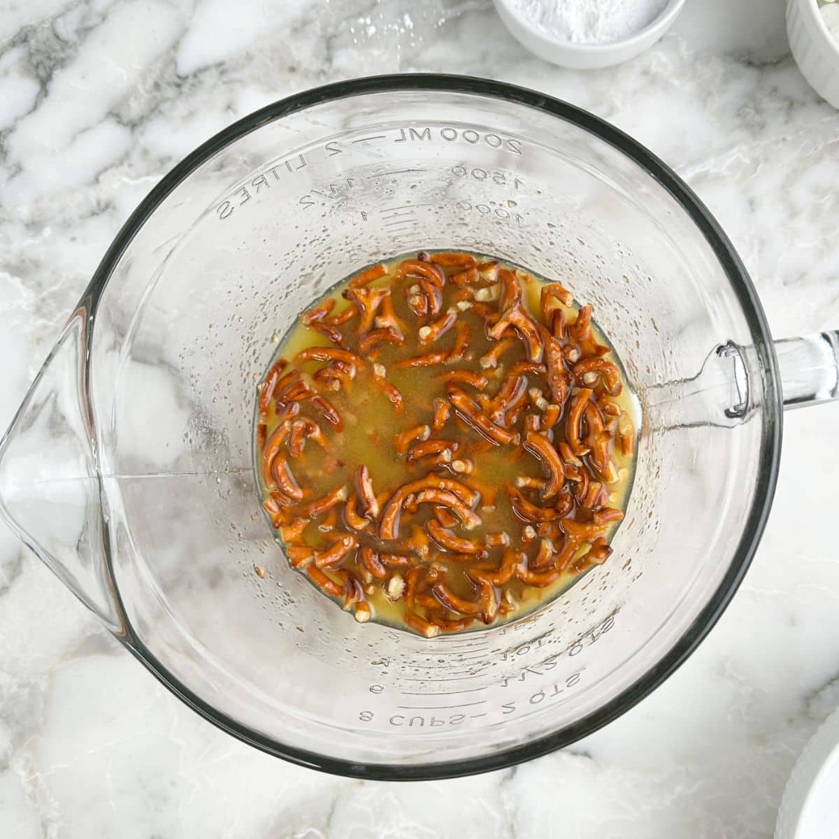Bowl of pretzels mixed with melted butter. 