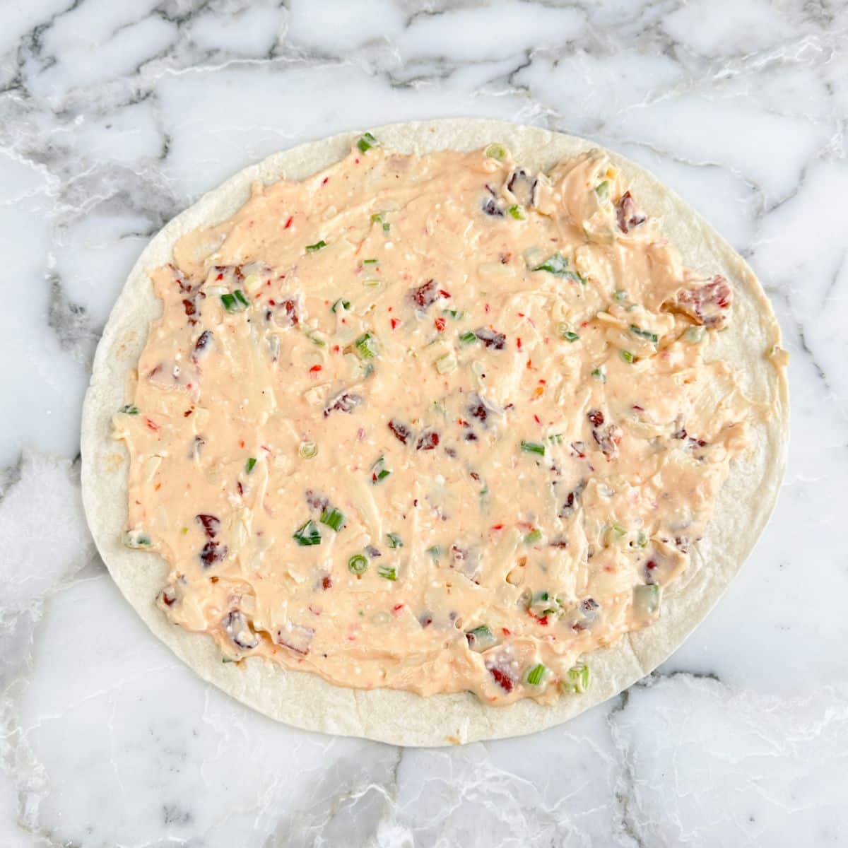 Tortilla with cream cheese mixture on top. 