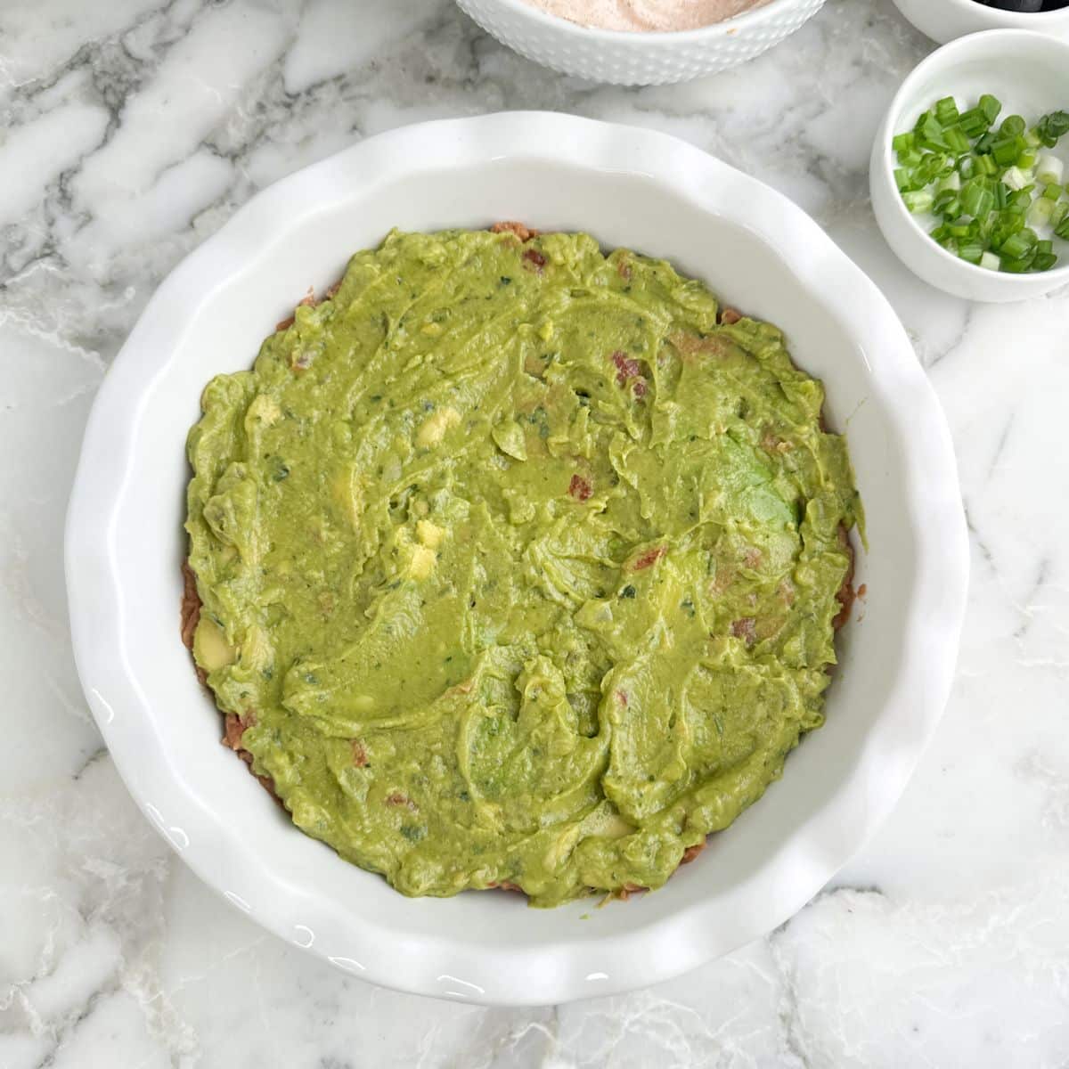 Pie dish with guacamole spread out.
