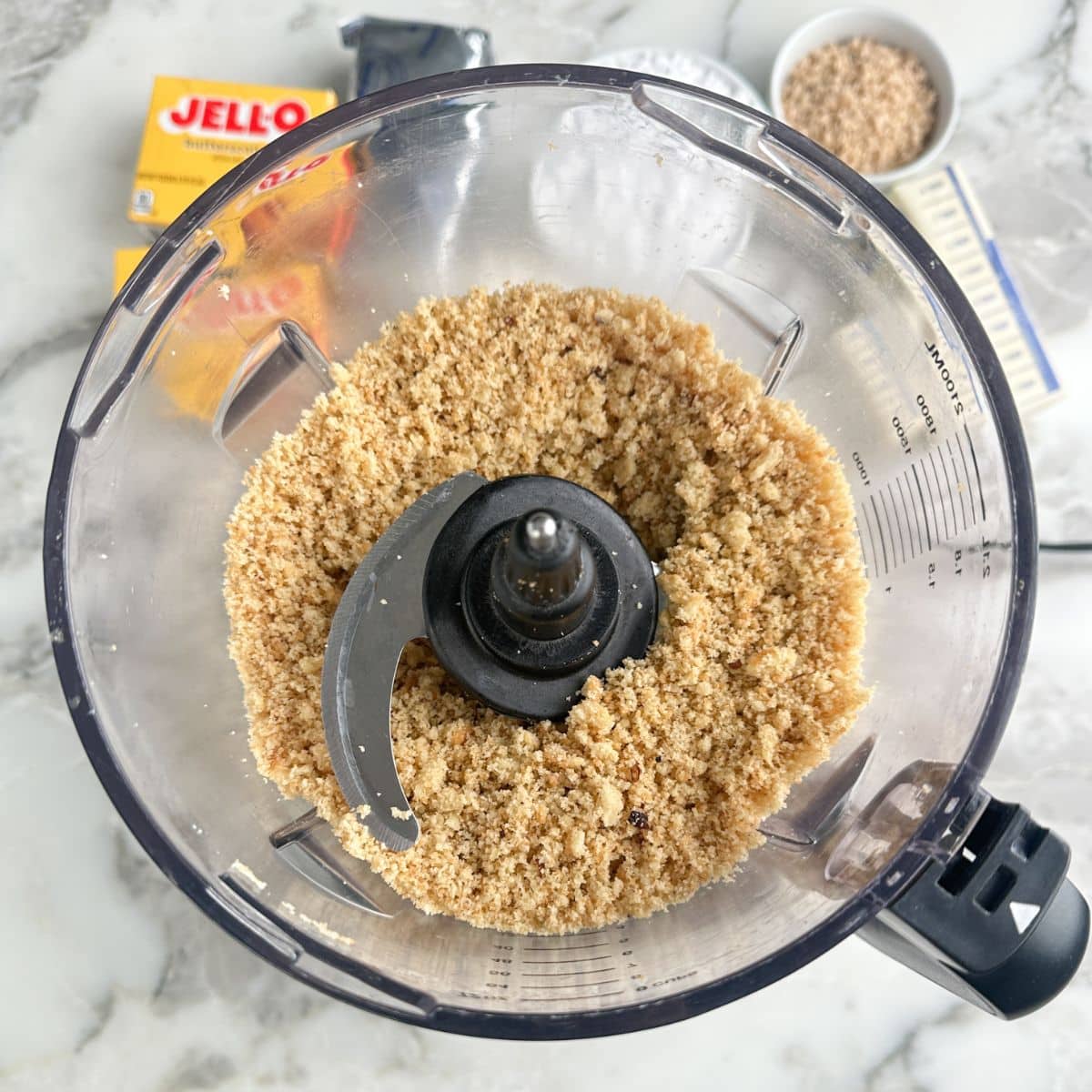Food processor with crush pecan sandies cookies.