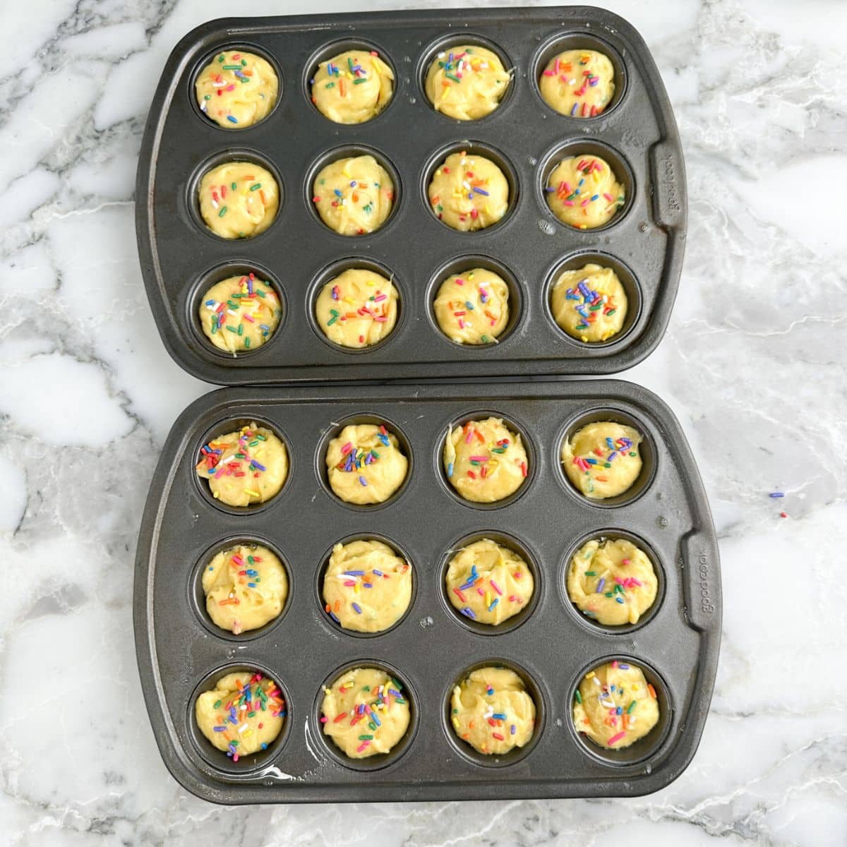 Mini muffin tins with cake batter.