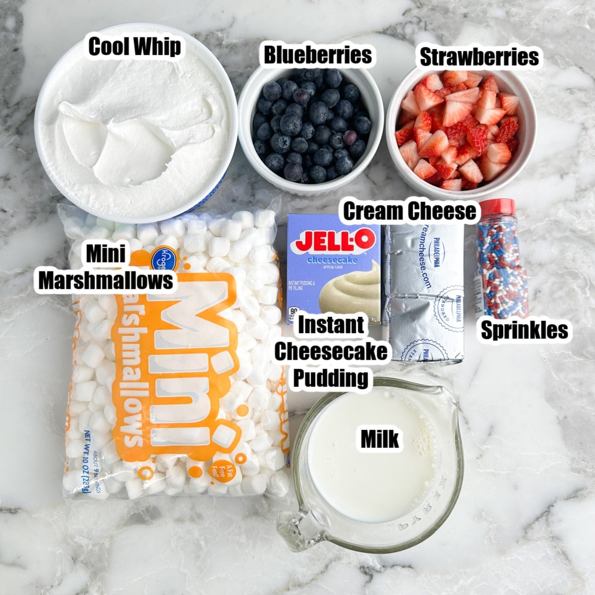 Bowl of Cool Whip, mini marshmallows, instant pudding mix, milk, cream cheese, and bowls of blueberries, and strawberries. 