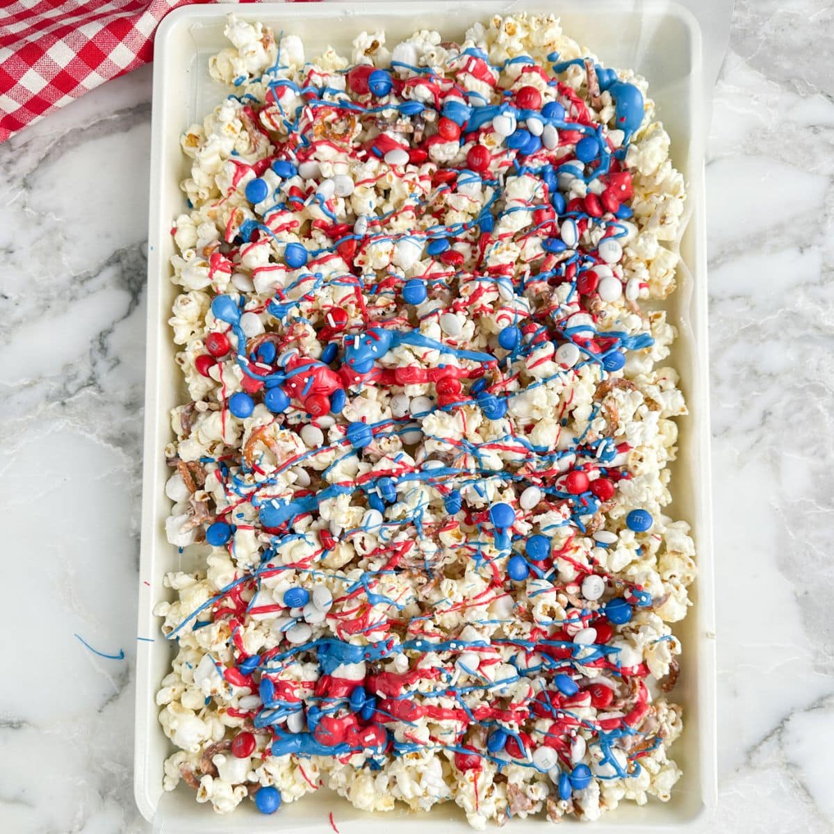 Baking sheet with red, white, and blue, popcorn snack mix.