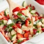 Spoon with strawberry cucumber salad.