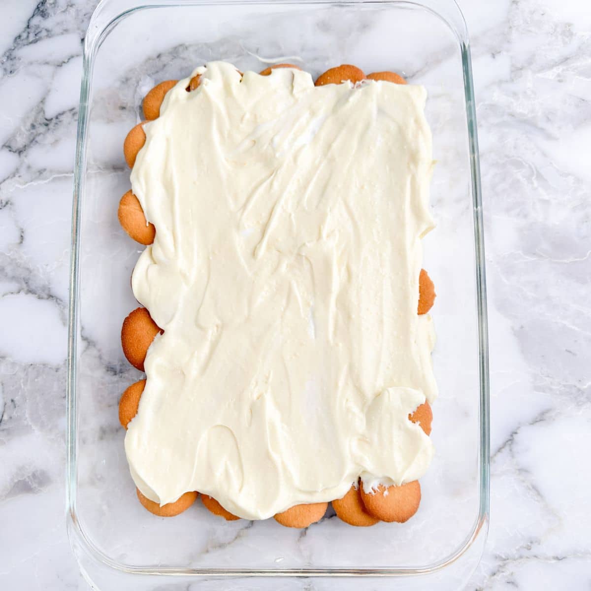 Nilla wafers topped with pudding in a baking dish. 