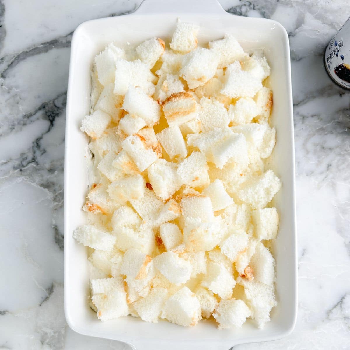Baking dish with cubed angel food cake. 