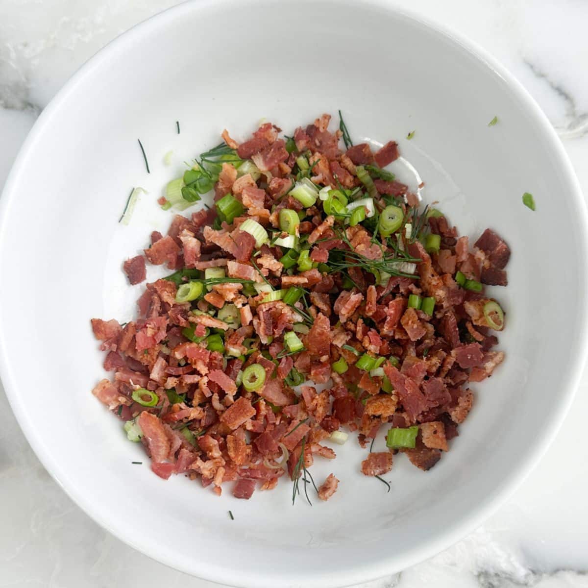 Bowl of bacon bits and green onions.