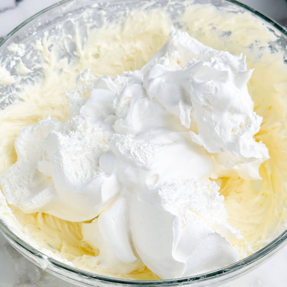 Bowl of whipped topping and whipped cream cheese.