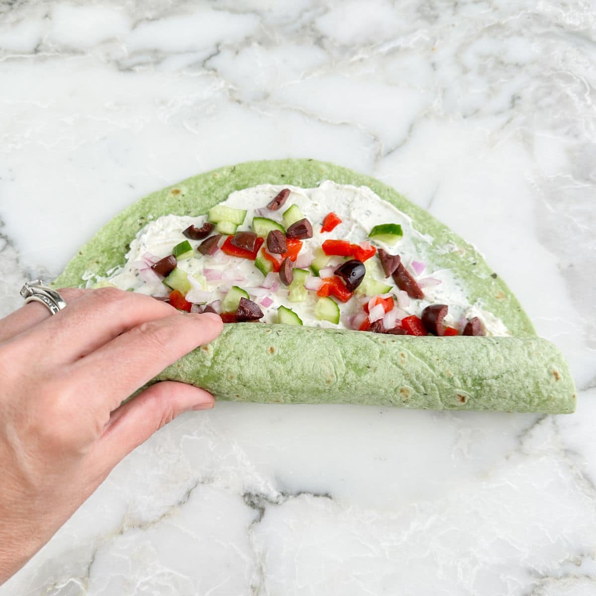 Tortilla pinwheel being rolled up.