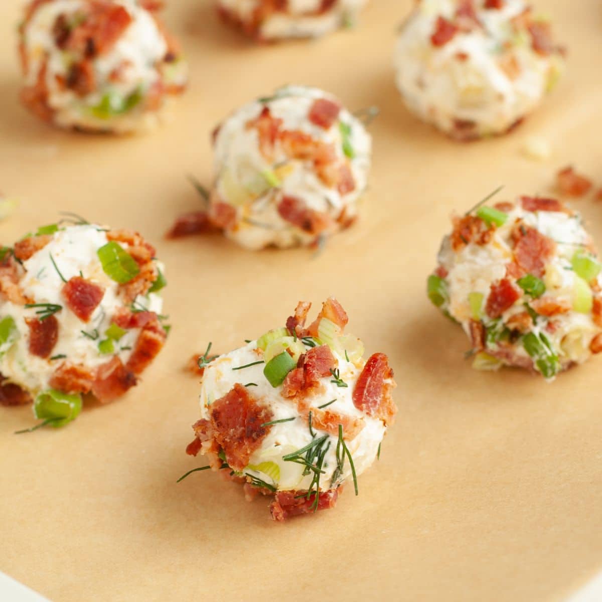 Mini dill pickle cheese balls on parchment paper.
