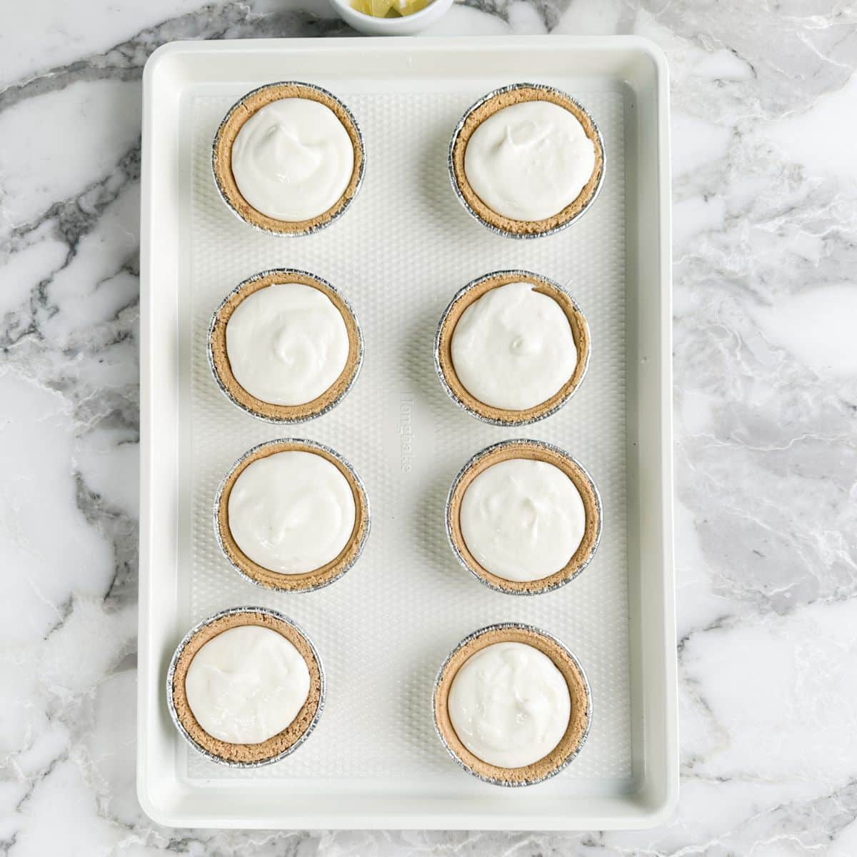 Mini lemonade pies on a baking sheet.