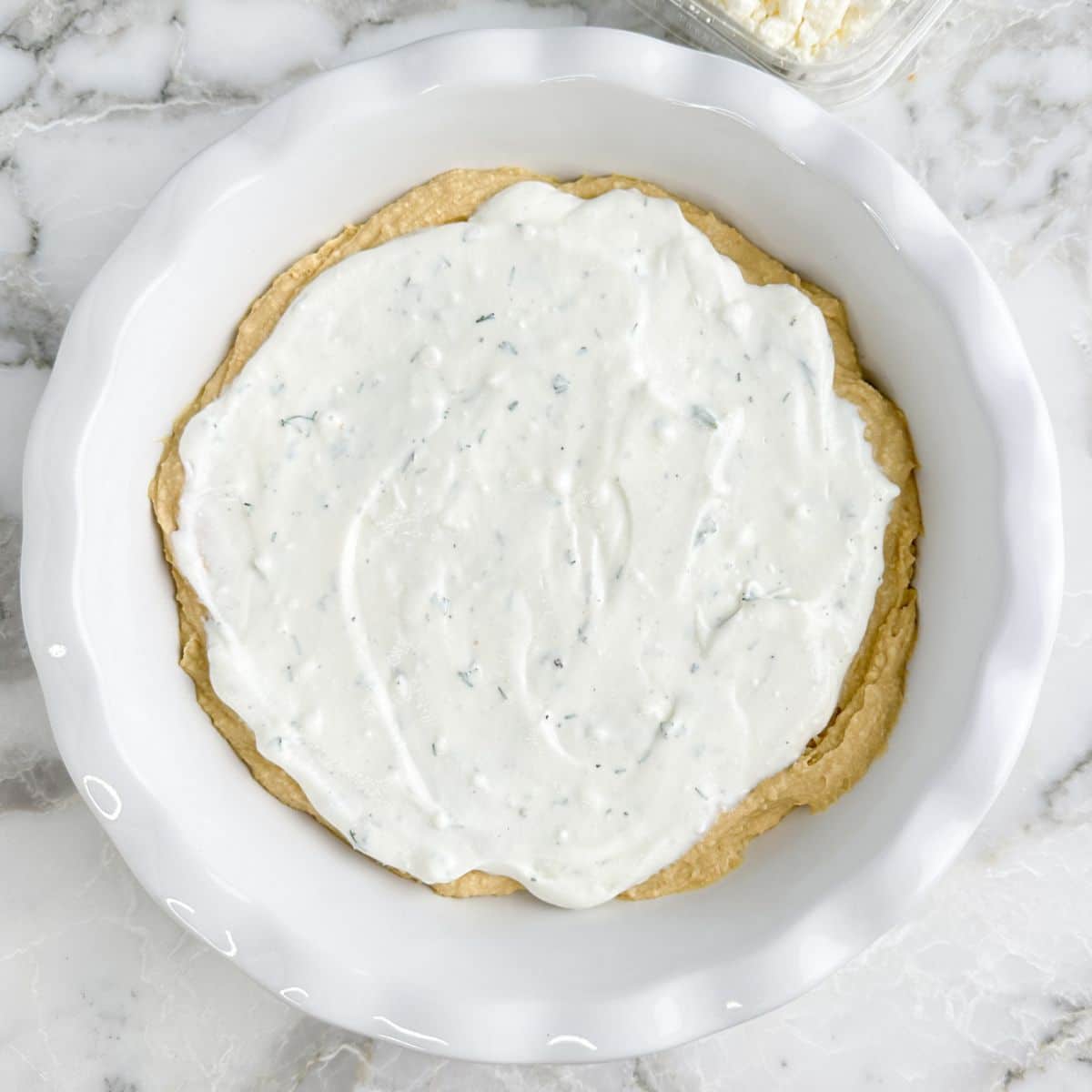 Pie dish with hummus and Greek yogurt.