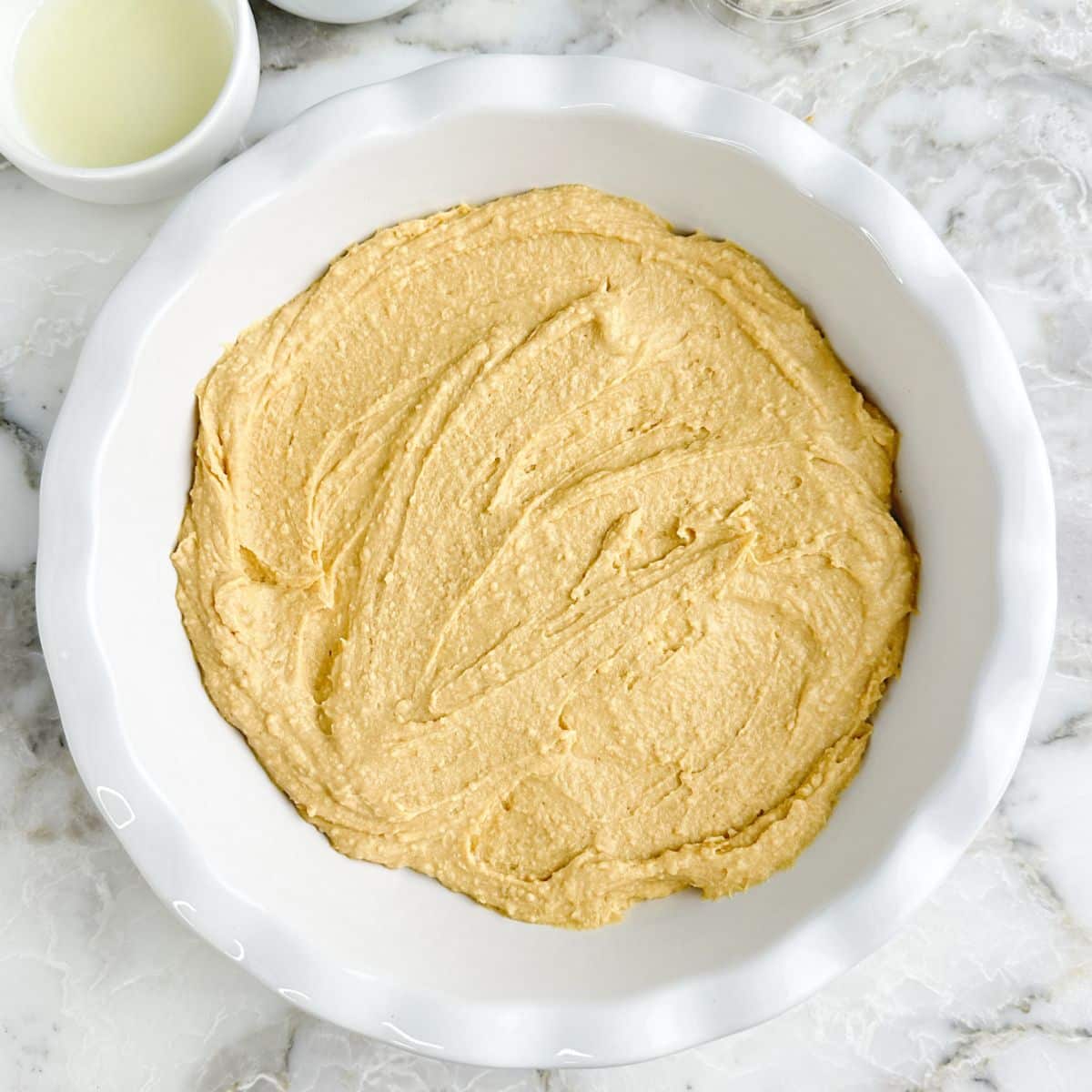 Pie dish with hummus spread in the dish.
