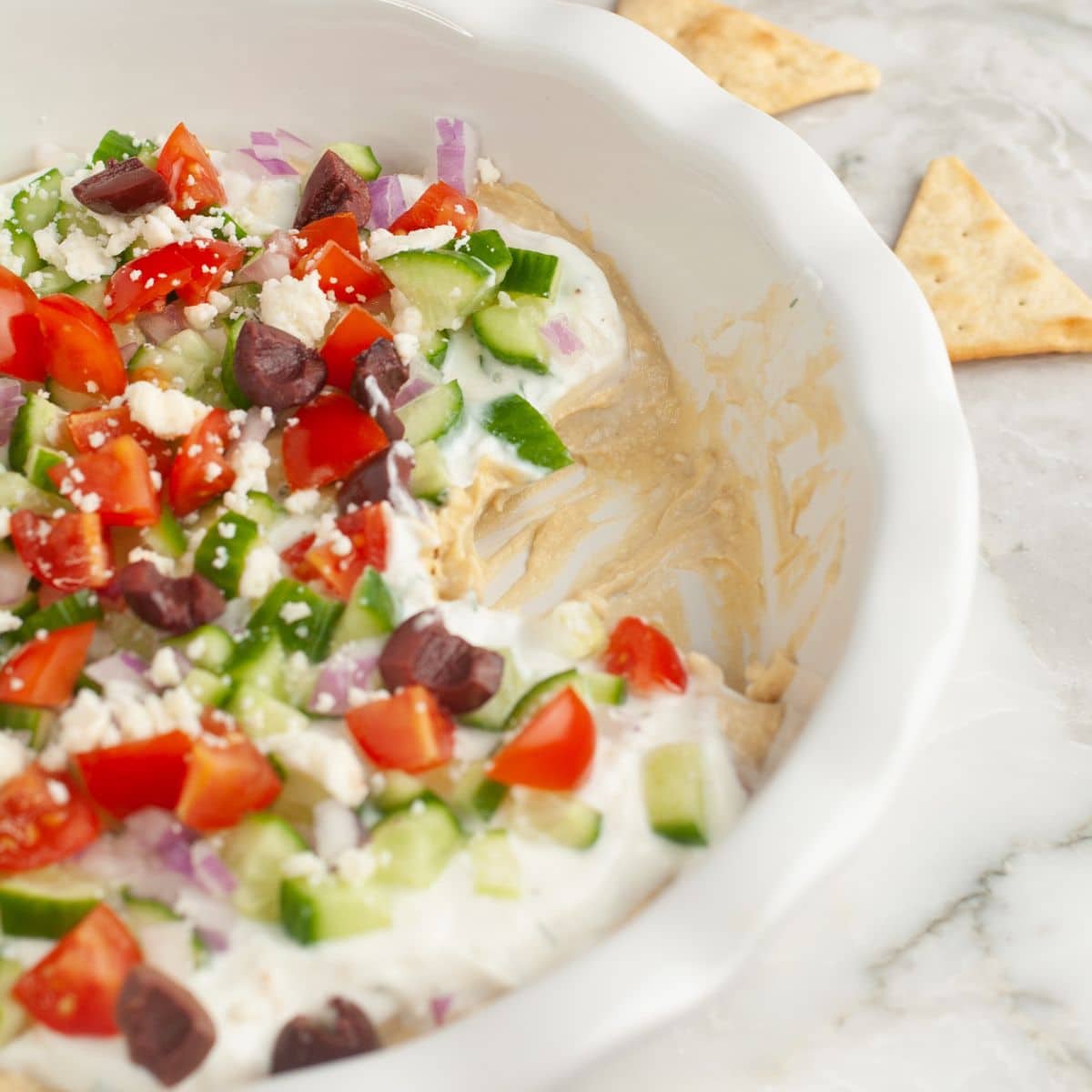 Greek layer dip in a pie dish.