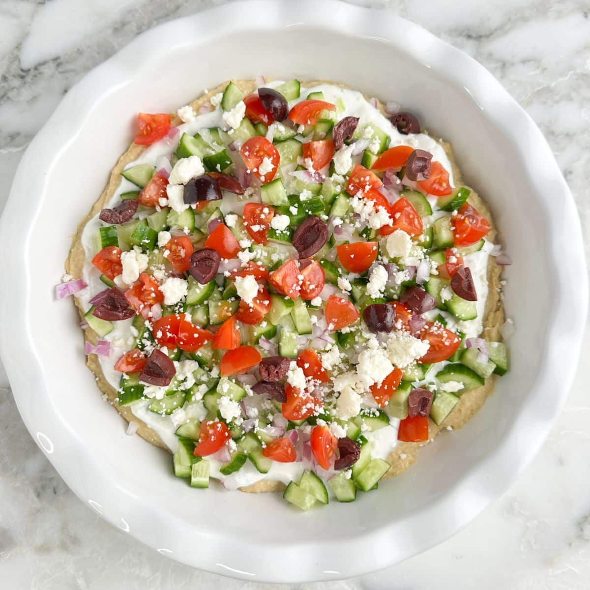 Pie dish with Greek layer dip.