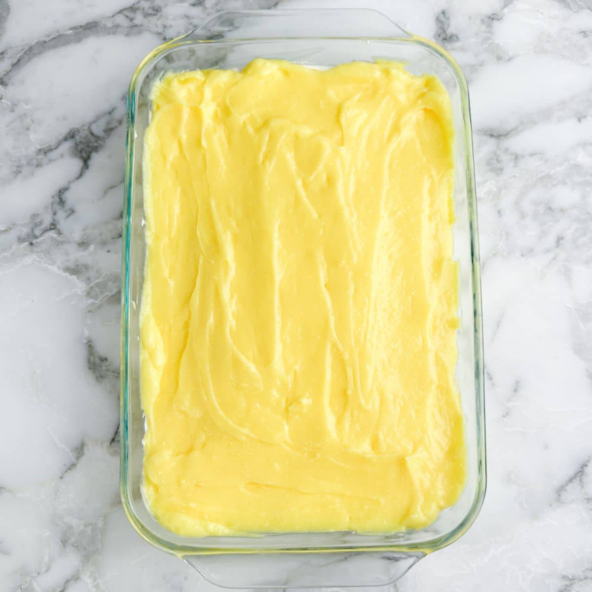 Lemon pudding layer in a baking dish.