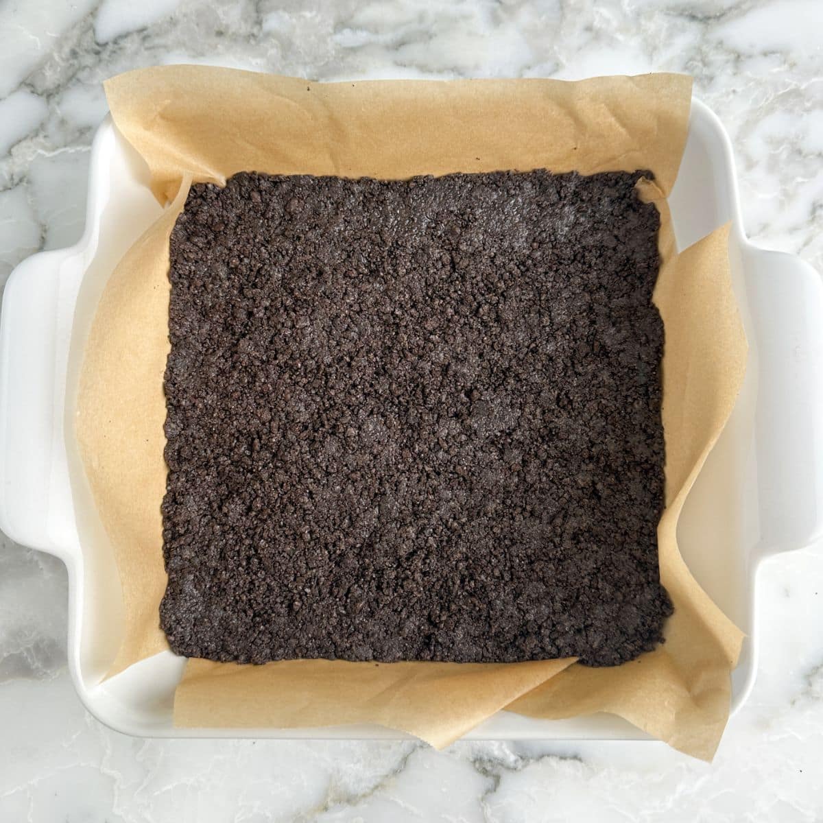 Oreo crust in a baking pan. 