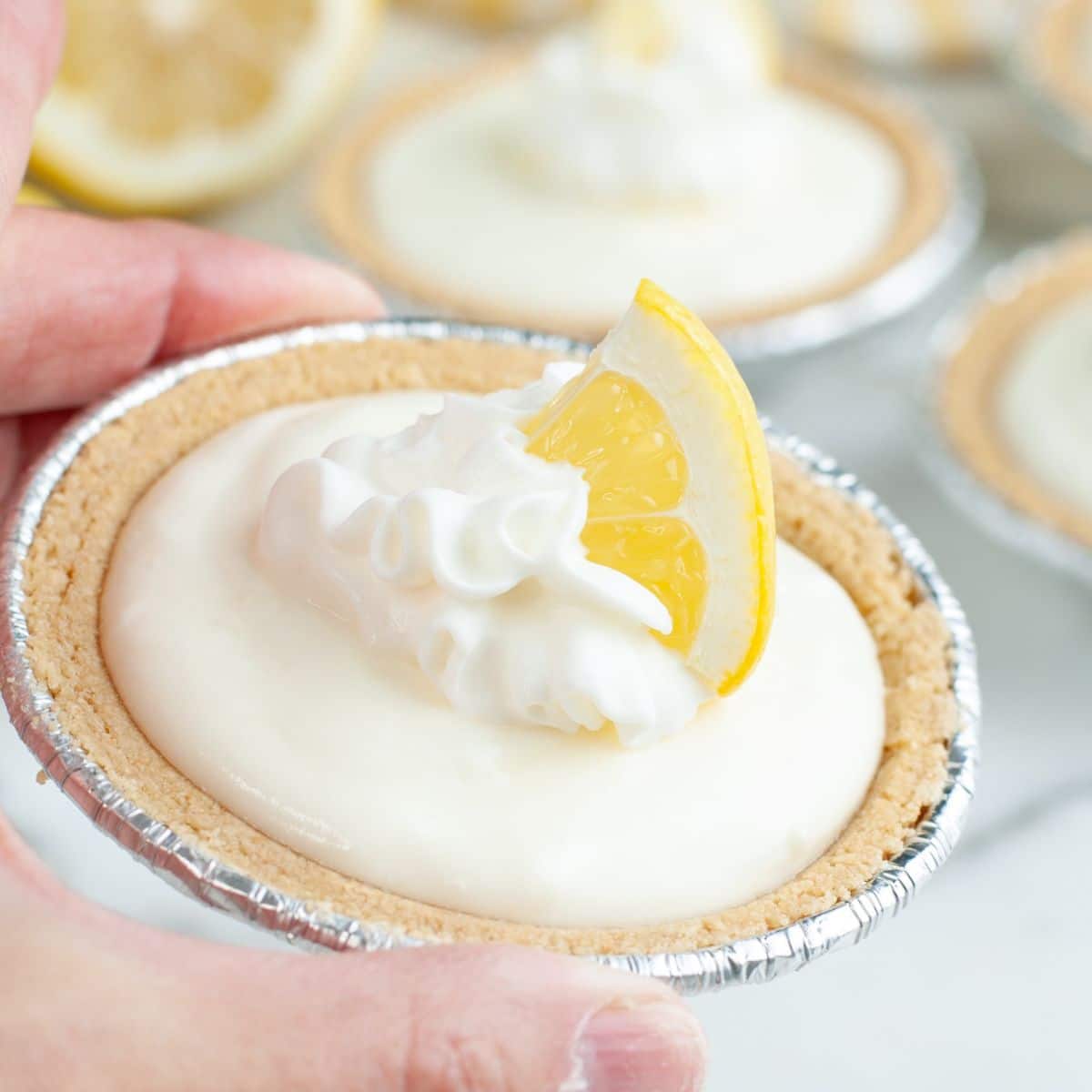 Hand holding a lemonade pie.