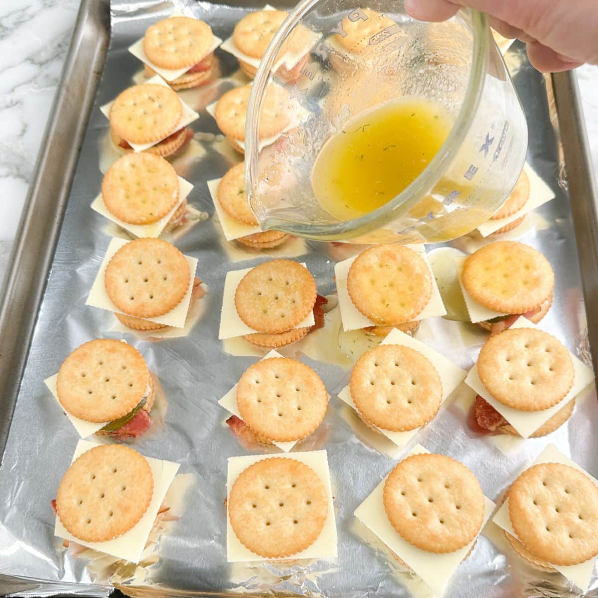 Melted butter being poured over crackers.